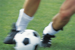 Bild på två fötter och en fotboll.